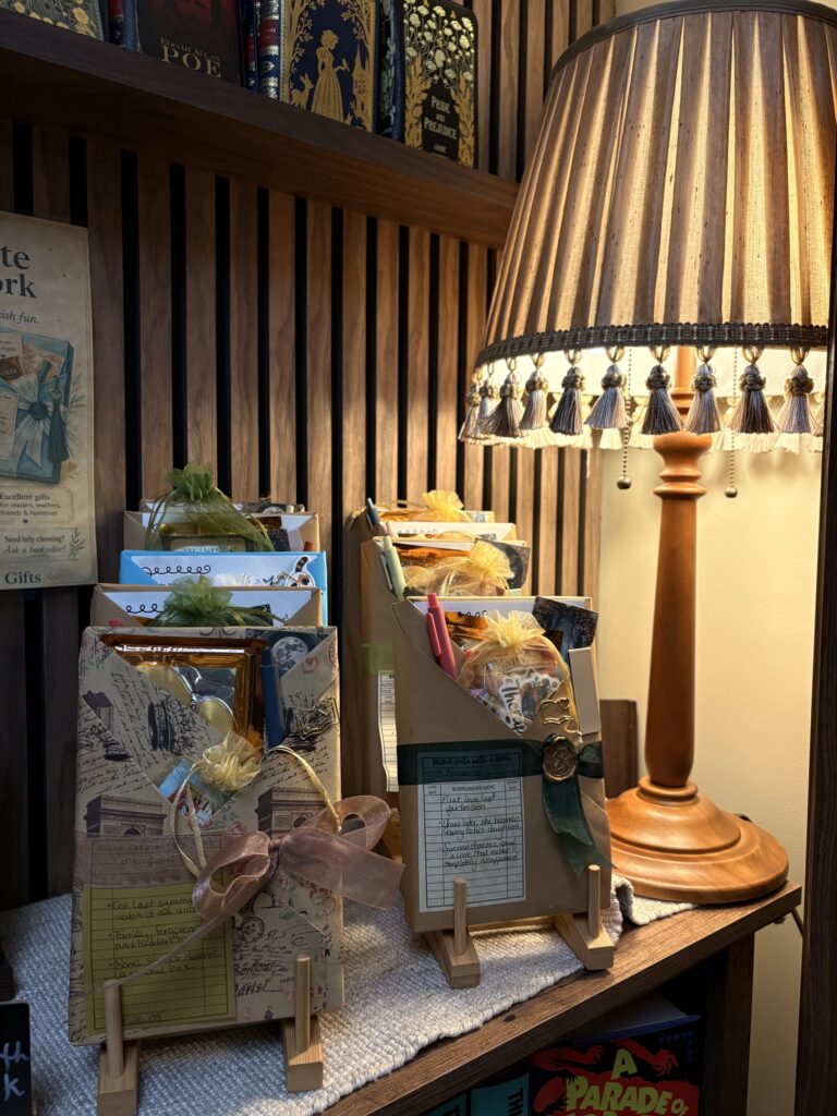 Wrapped Blind Date with a Book selections displayed on small easels beside a glowing table lamp.