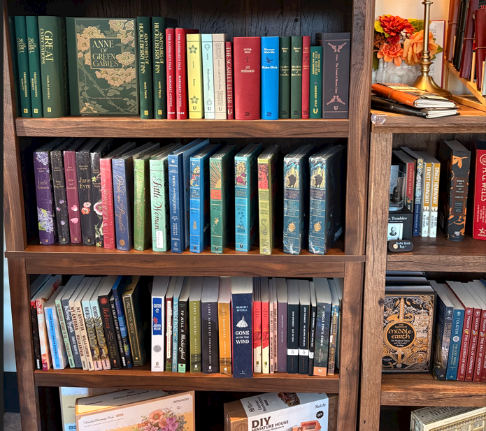 Colorful hardcover and paperback books arranged on wooden shelves at Cashmere Books & Gifts.